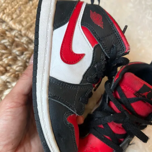 KIDS BLACK AND RED RETRO JORDAN 1  MID SIZE 10C. USED IN GOOD CONDITION.