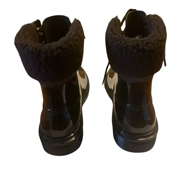 See By Chloe ankle-high PVC boots in black. Dark brown shearling.