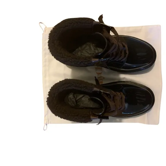 See By Chloe ankle-high PVC boots in black. Dark brown shearling.