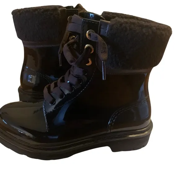 See By Chloe ankle-high PVC boots in black. Dark brown shearling.